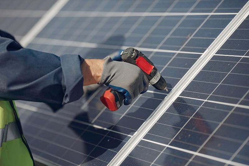 Instalador trabajando en el montaje de paneles solares fotovoltaicos para autoconsumo.