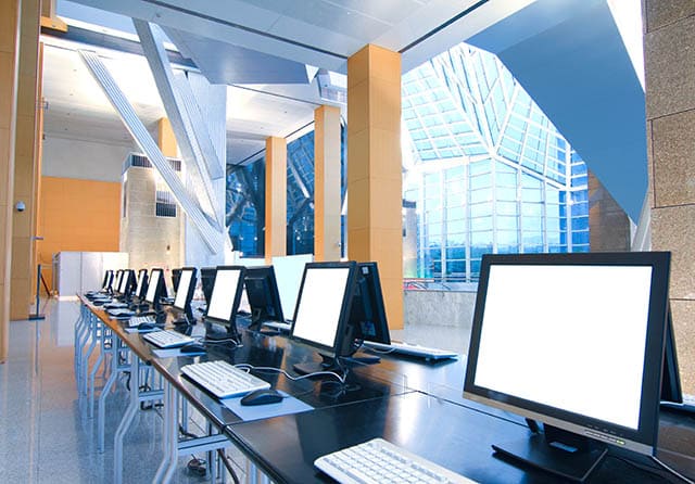 Puestos de trabajo equipados con ordenadores y monitores en un espacio profesional.