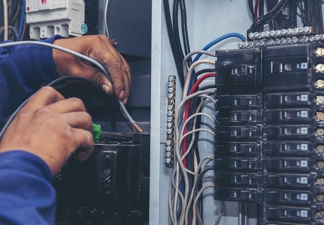 Técnico realizando trabajos de mantenimiento y reparación en un cuadro eléctrico.
