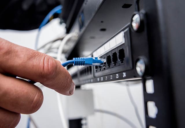 Conexión de un cable Ethernet a un equipo de red para la instalación de comunicaciones.