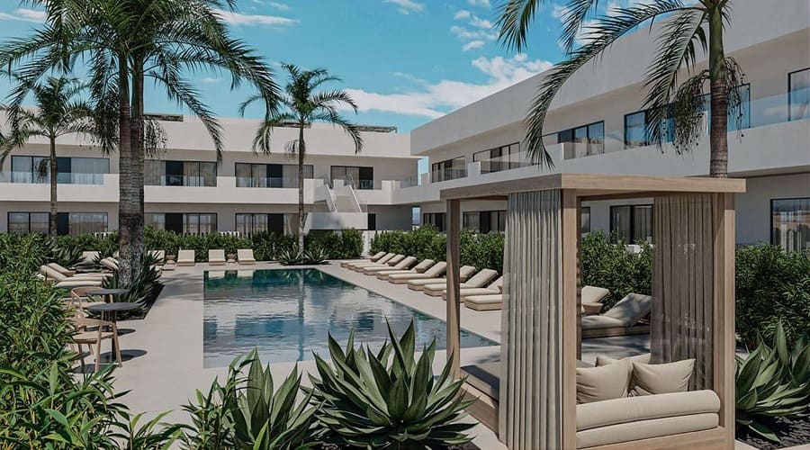 Complejo residencial moderno con piscina, zonas ajardinadas, palmeras y áreas de descanso.