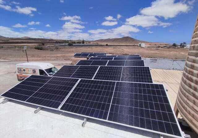 Instalación de paneles solares fotovoltaicos sobre cubierta en una zona rural.